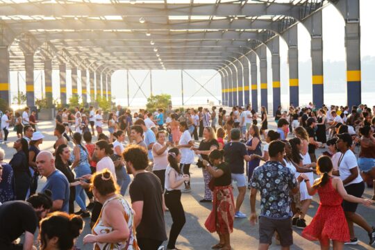 A group of people dancing during a Sunset Salsa class on Pier 76