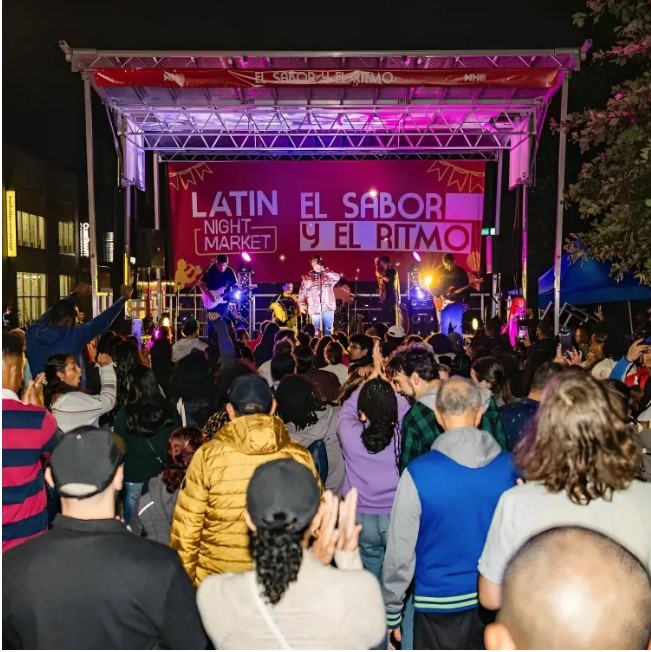 New York Latin Night Market attendees watch a performance on a stage