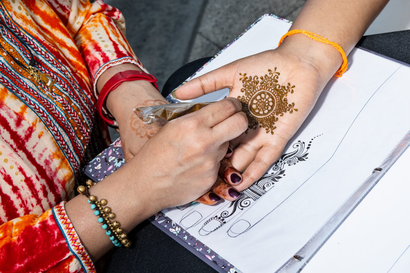 A Park visitor receives a henna tattoo on their palm