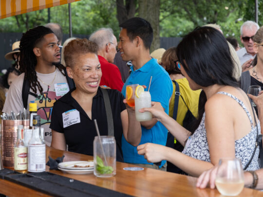 Two women clink cocktail glasses at annual Hudosn River Park Membership party at Drift In