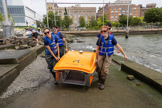 Four HRPK River Project staffers carry Gulp the Wasteshark up from the Gansevoort Peninsula shoreline