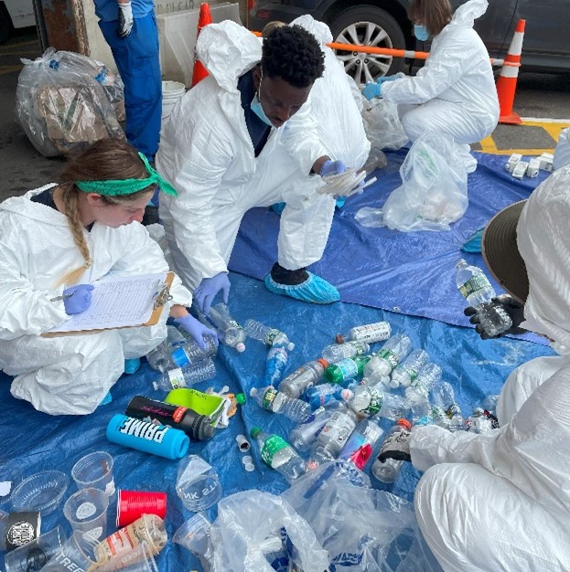 HRPK River Project staffers and volunteers sort collected plastic waste on a tarp