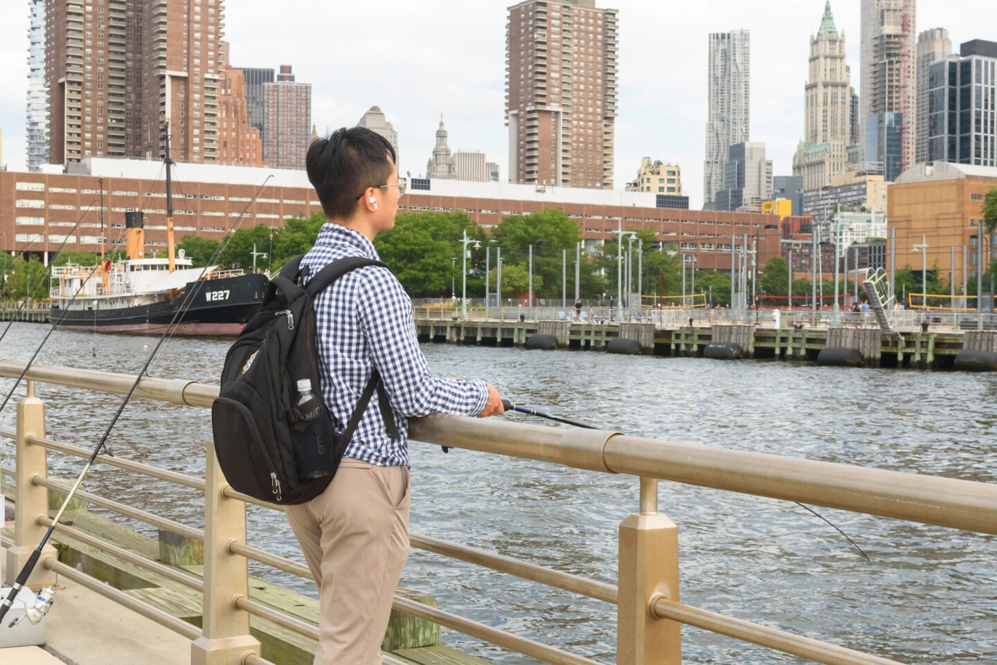 A man with a backpack casts a fishing line off of Pier 26