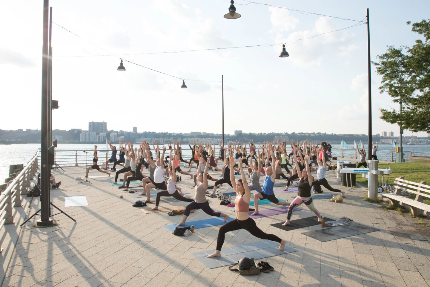 Participants in a Healthy on the Hudson yoga class hold a pose on Pier 64