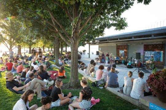 Park visitors relax on the lawn during a Jazz at Pier 84 concert