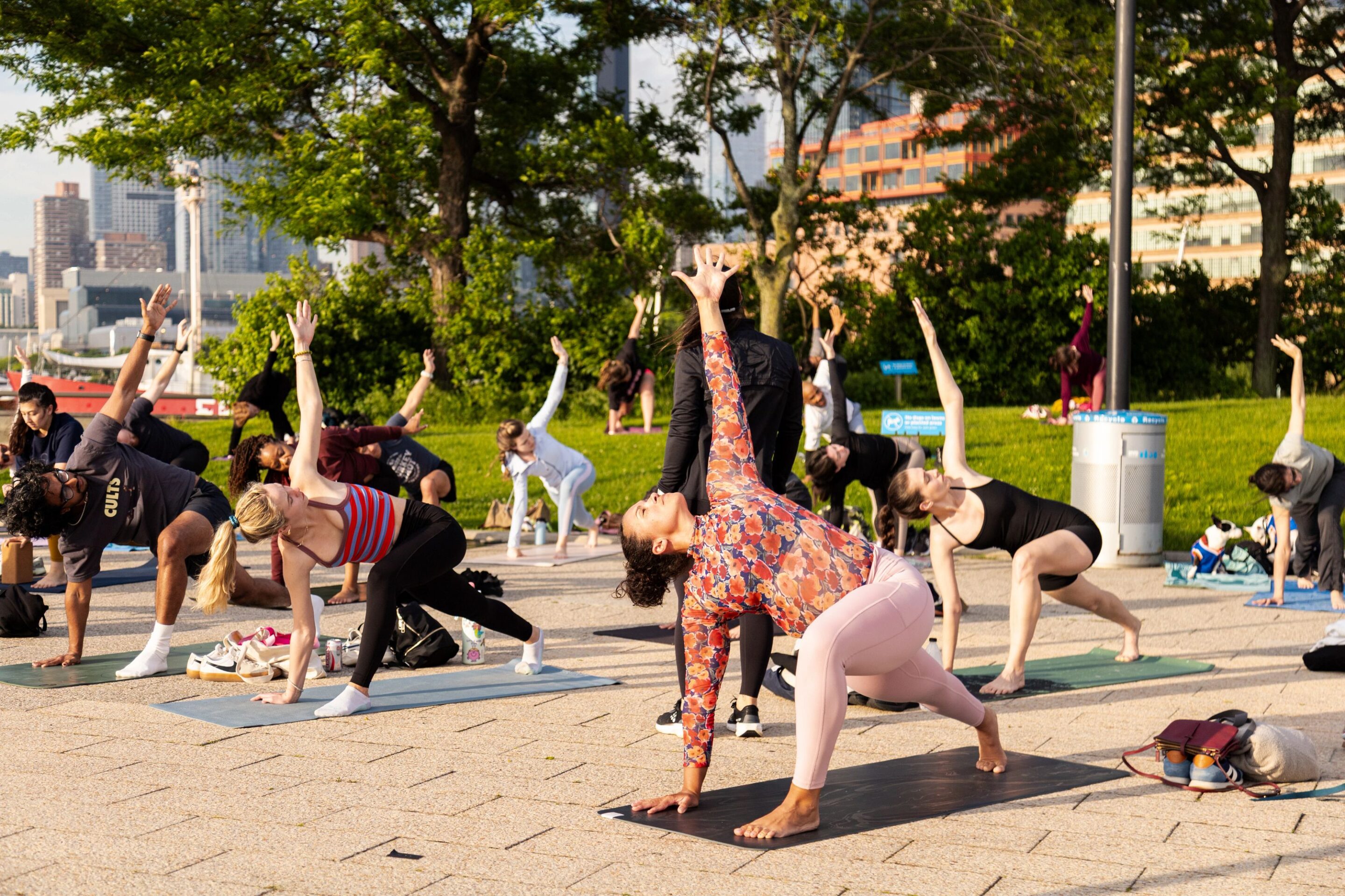 Healthy on the Hudson Yoga class participants hold a "Reverse Warrior" pose on Pier 64