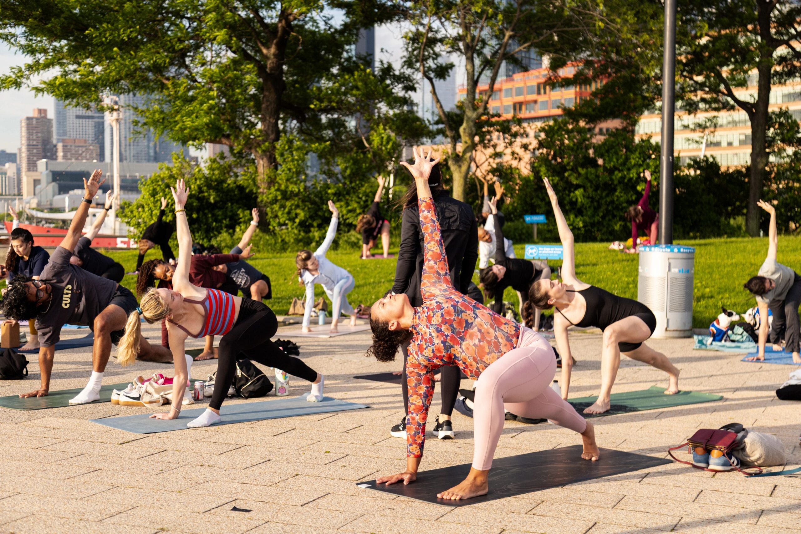 Healthy on the Hudson Yoga class participants hold a "Reverse Warrior" pose on Pier 64