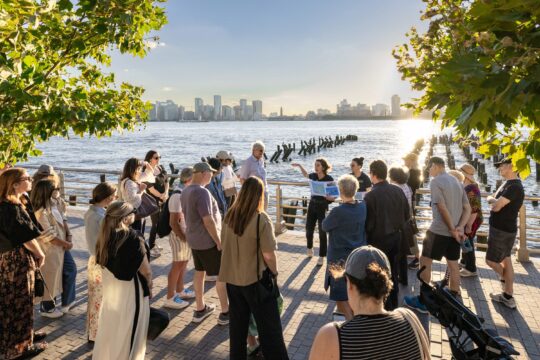 An HRPK River Project staffer leads a group on a Shoreline Strolls tour of Gansevoort Peninsula
