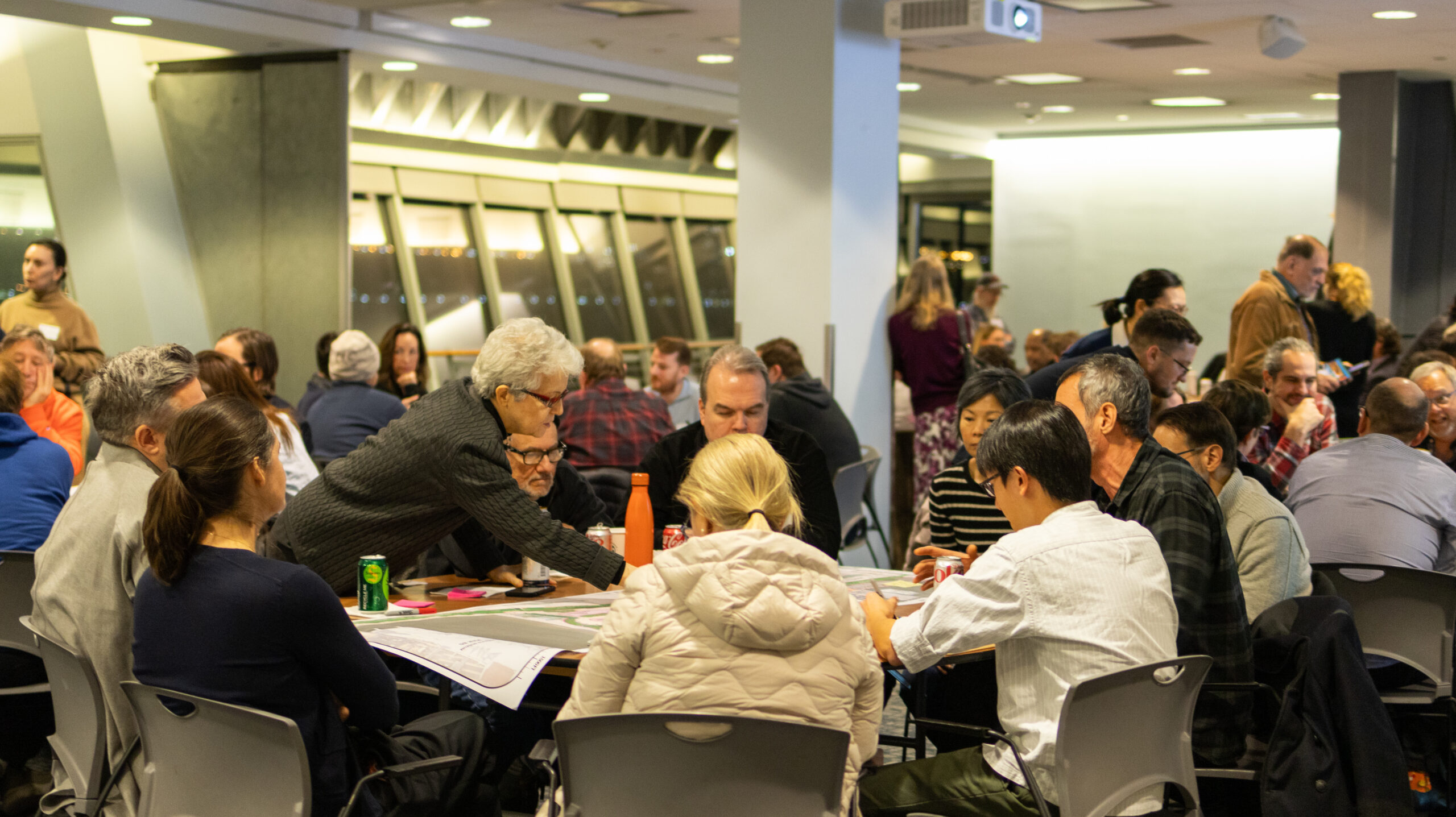 Groups of people at tables discussing ideas for the Hudson River Park Esplanade during a W 29–W 44 Esplanade & Landscape Engagement Meeting at the Intrepid Museum