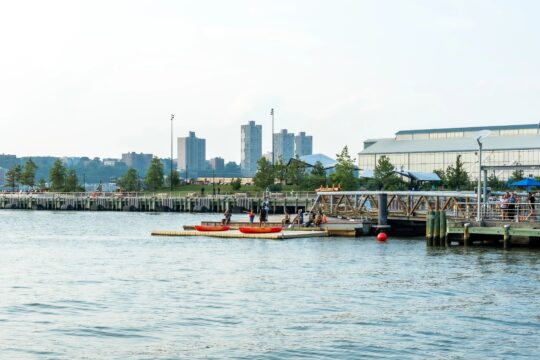 People in kayaks setting off from the Pier 96 Boathouse
