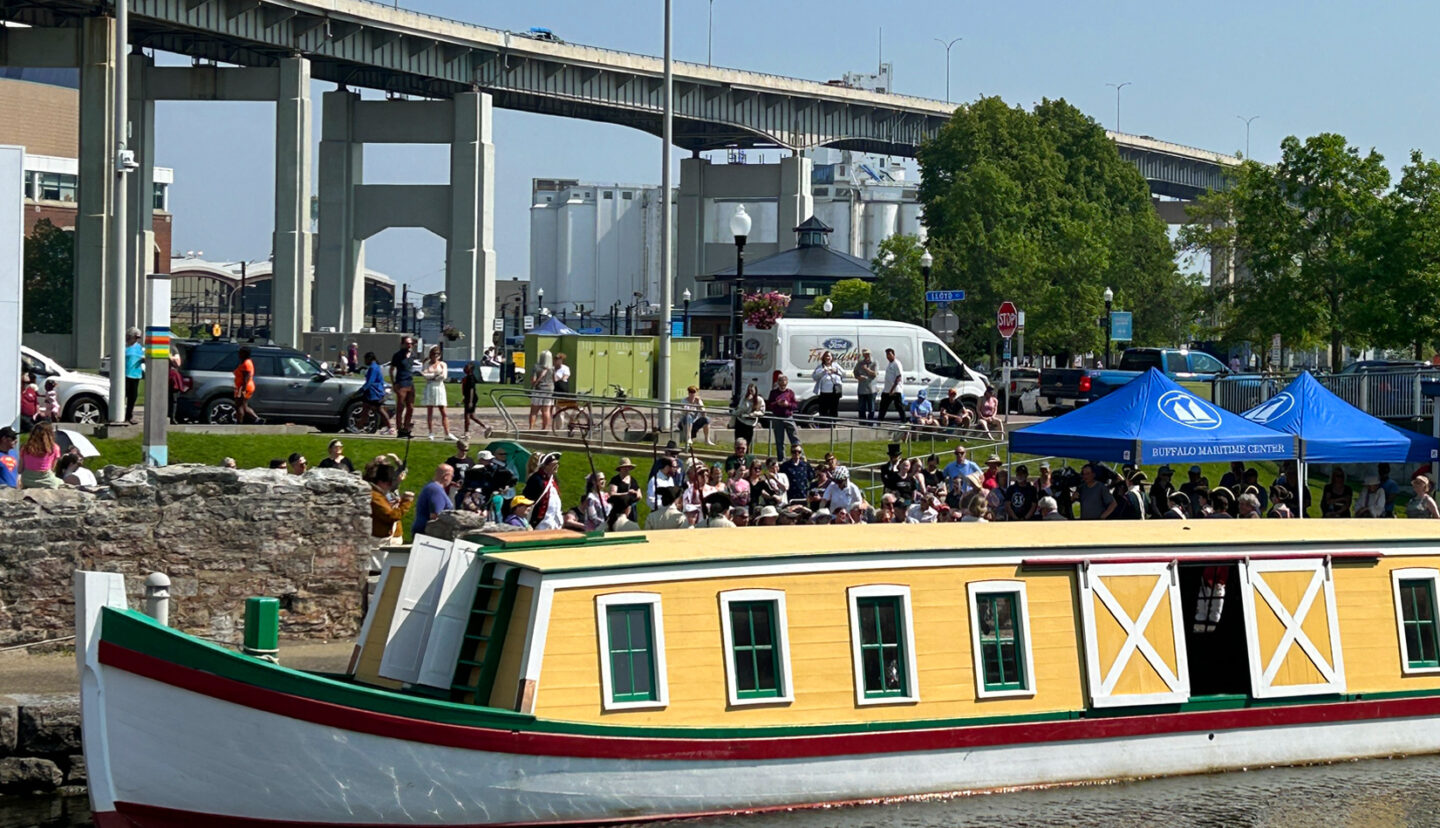 The river boat Seneca Chief docked in a park in Buffalo with a highway overpass visible in the backgruond