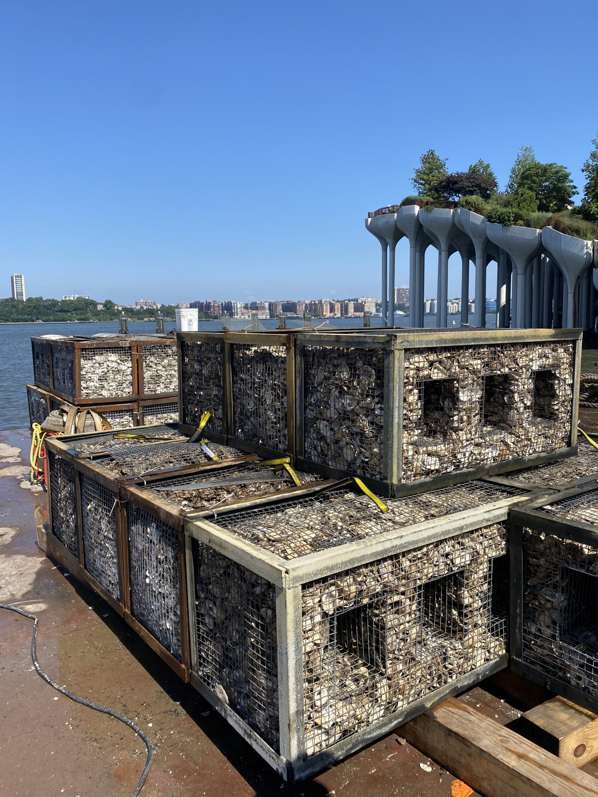 A gabion filled with oyster shells sits on a platform on Gansevoort Peninsula; Little Island is visible in the background