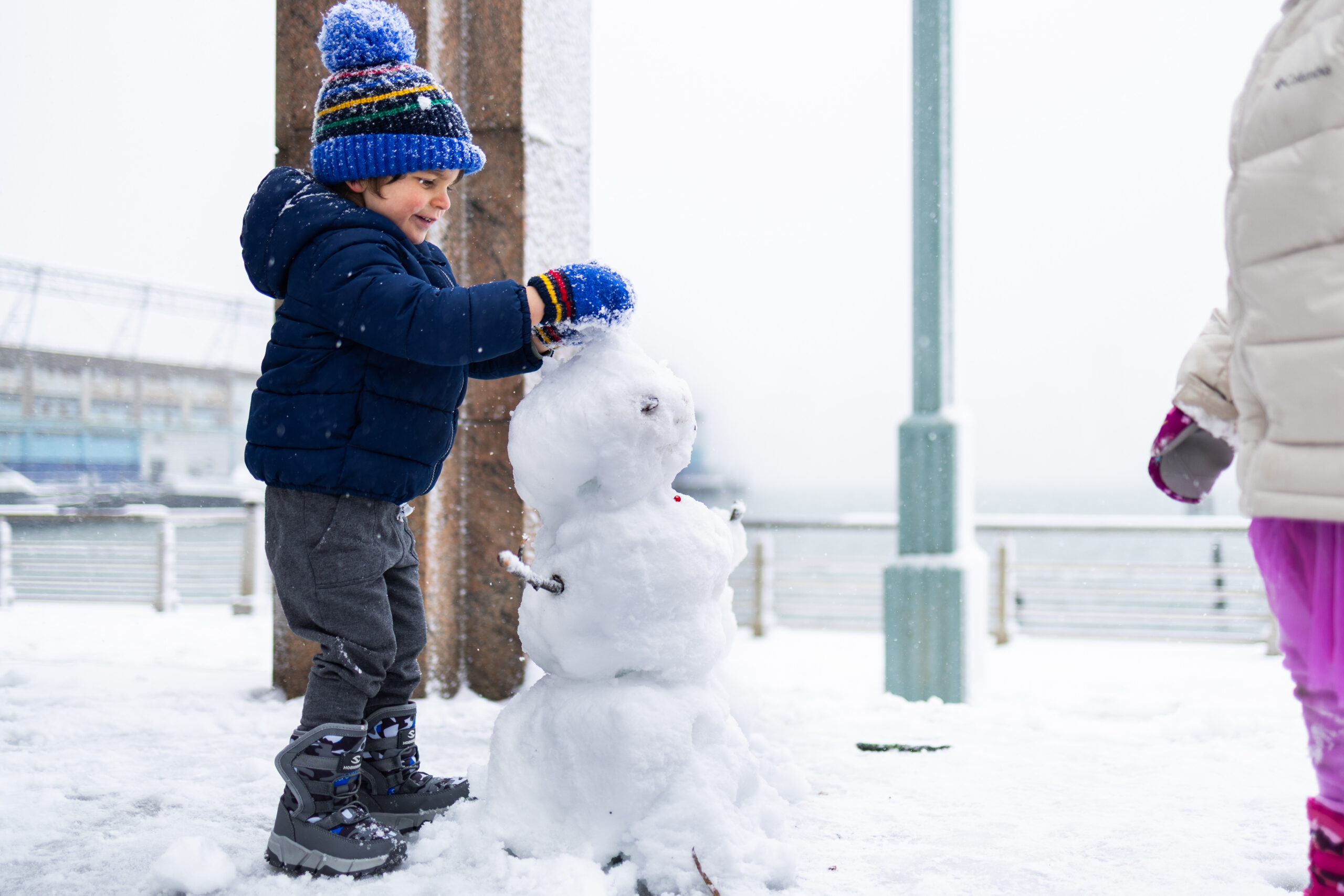 Child building snowman in Hudson River Park