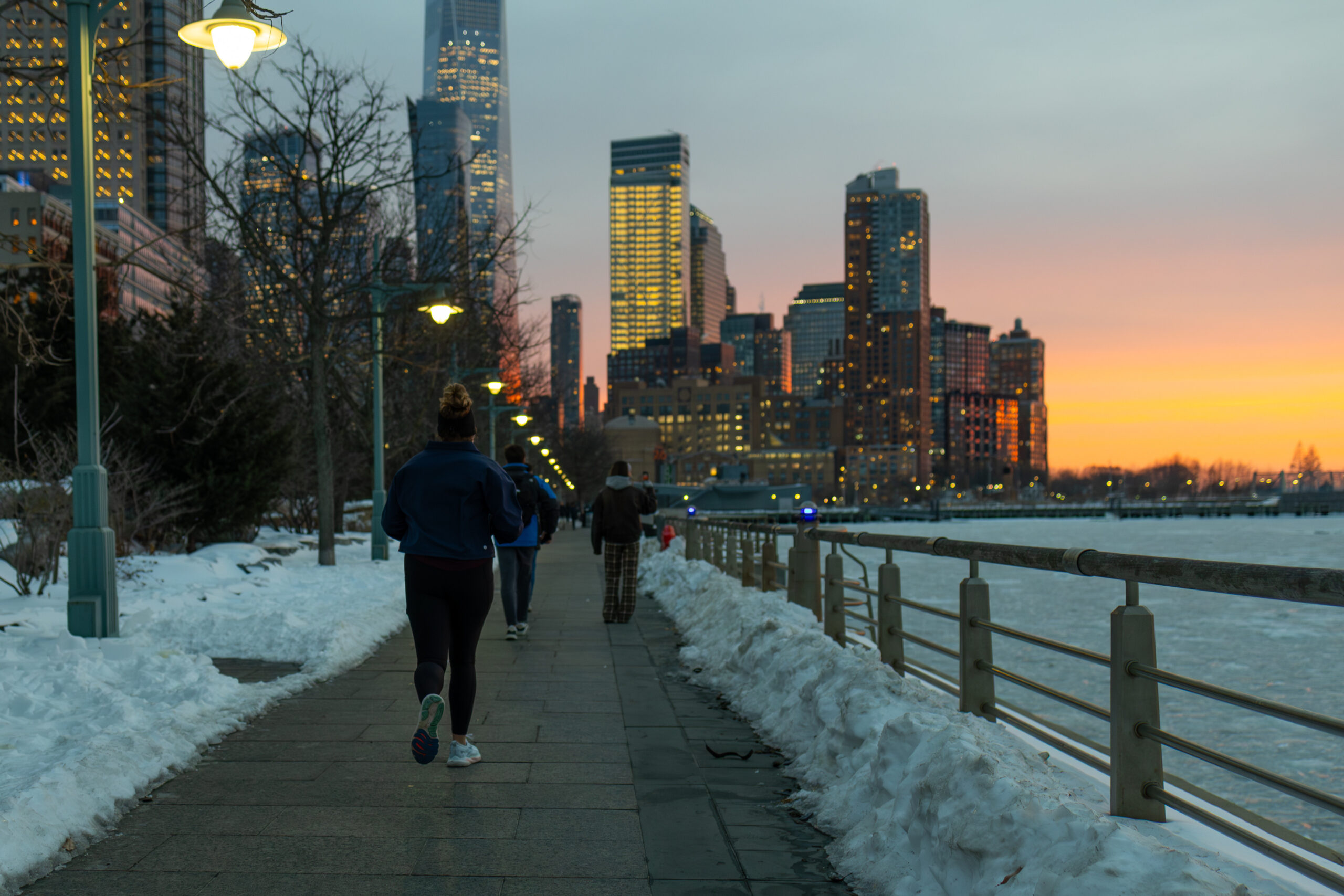 sunset over snowy waterfront, person walking, in Tribeca in Hudson River Park