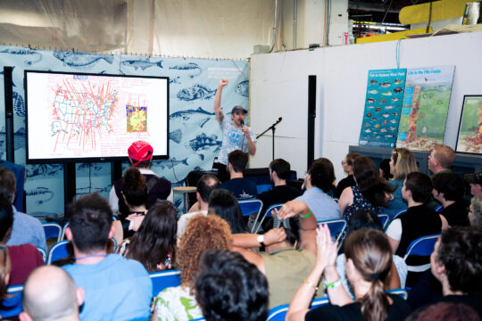 Scientist presenting on stage at HRPK