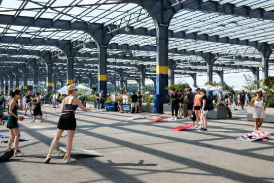People playing corn hole on Pier 76 during the Blues BBQ Festival