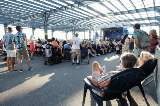 People enjoying the Blues BBQ Festival from Adirondack chairs