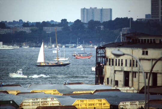 Boats pass a pier building on the Hudson River