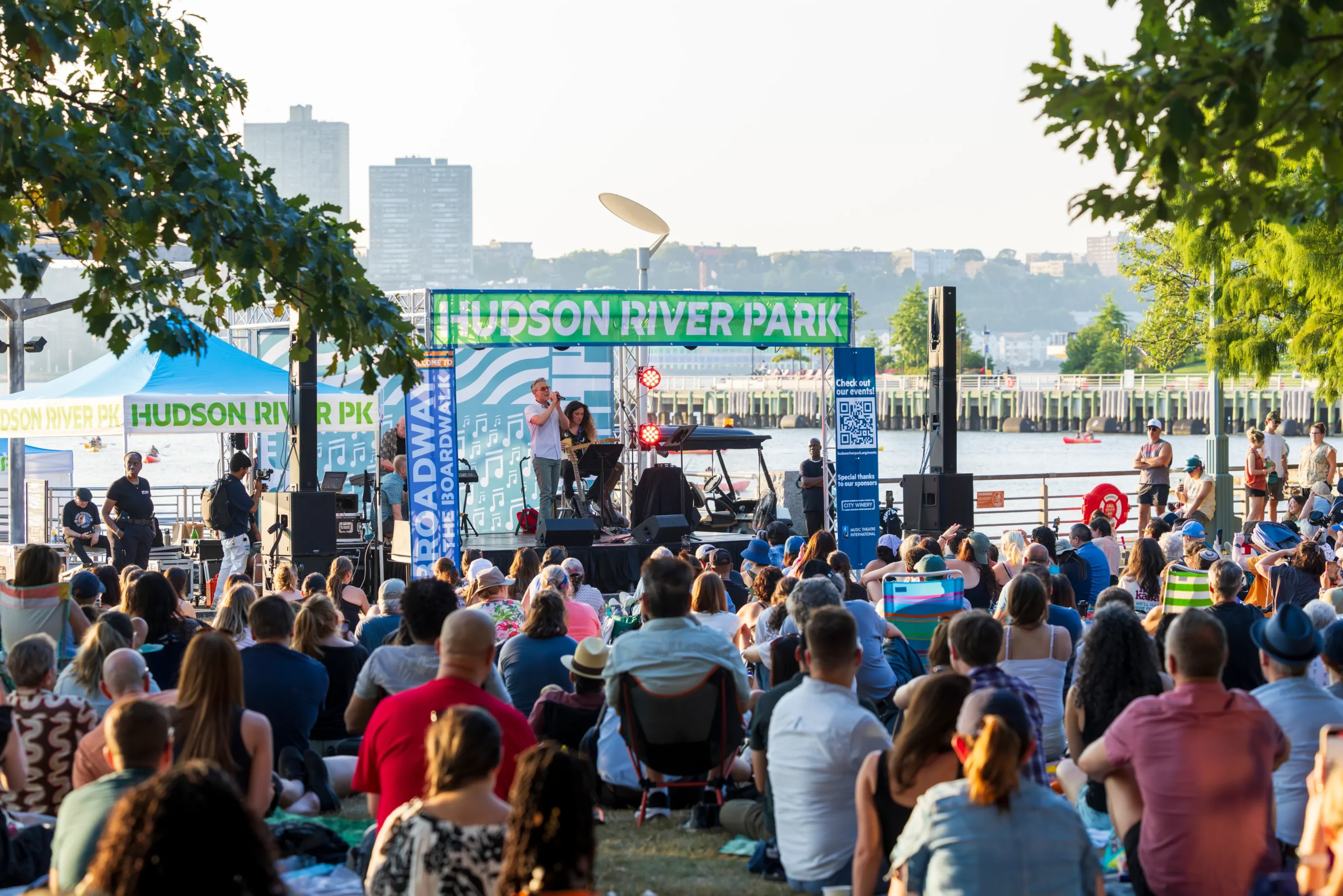 A large audience watches a Broadway by the Boardwalk concert from the Clinton Cove lawn