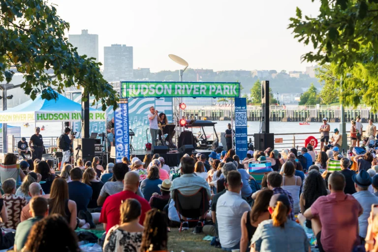 A large audience watches a Broadway by the Boardwalk concert from the Clinton Cove lawn