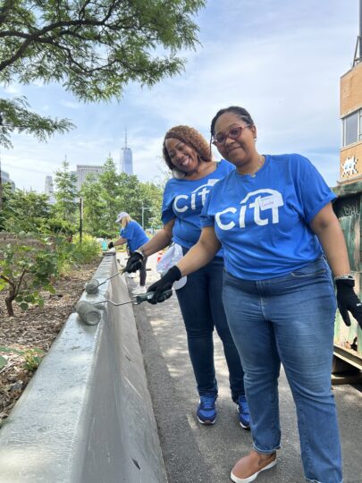 Citi volunteers painting near greenery