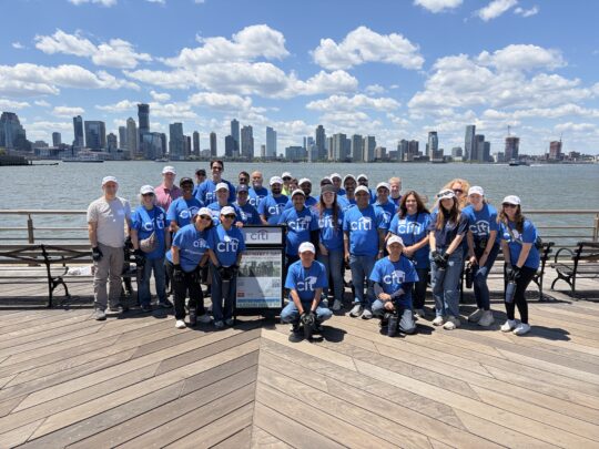 Citi volunteers posed in front of the Hudson River on a sunny day