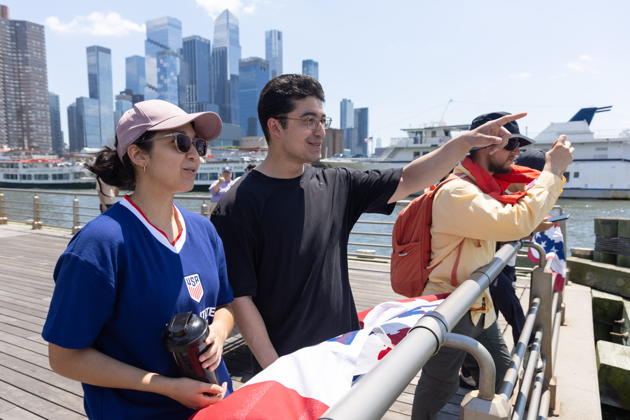 People gather at edge of Pier 84 pointing over Hudson River