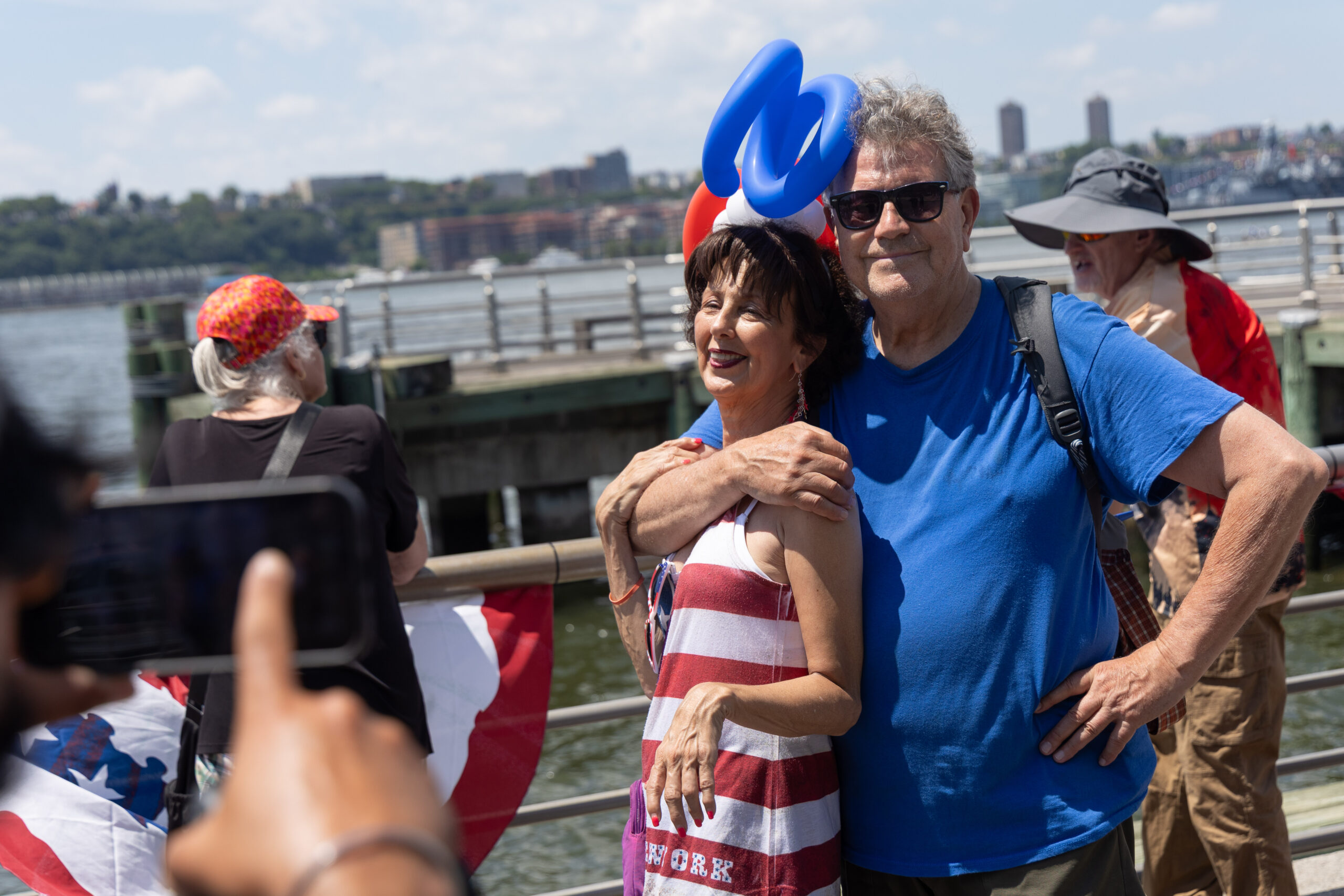 A couple in festive red, white and blue attire poses for photo