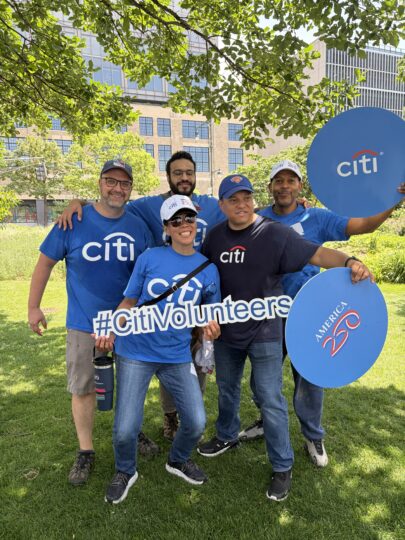 Citi volunteers posing in Hudson River Park with signs